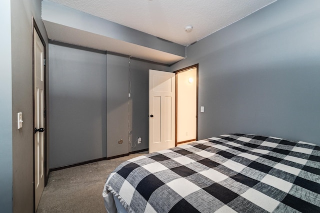 bedroom with carpet, a textured ceiling, and baseboards