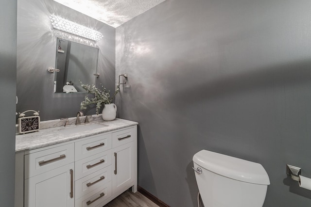 bathroom with vanity, toilet, and wood finished floors