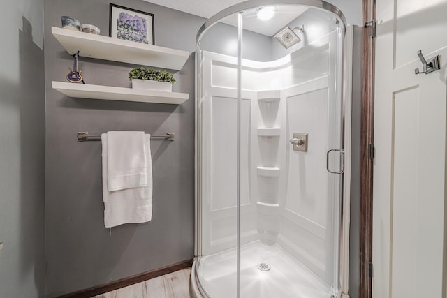 full bathroom with a stall shower and wood finished floors