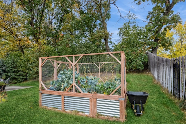 view of yard featuring fence and a vegetable garden