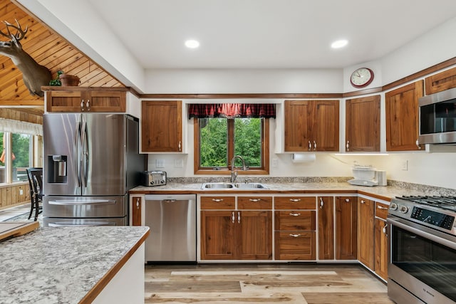 kitchen featuring light countertops, appliances with stainless steel finishes, a sink, and a healthy amount of sunlight