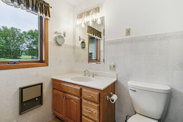 bathroom with vanity, toilet, and tile walls