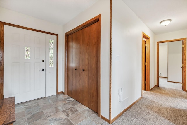 entrance foyer featuring baseboards, visible vents, and light colored carpet