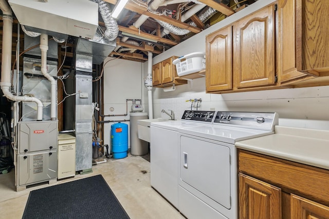 laundry area with washing machine and dryer, cabinet space, and heating unit