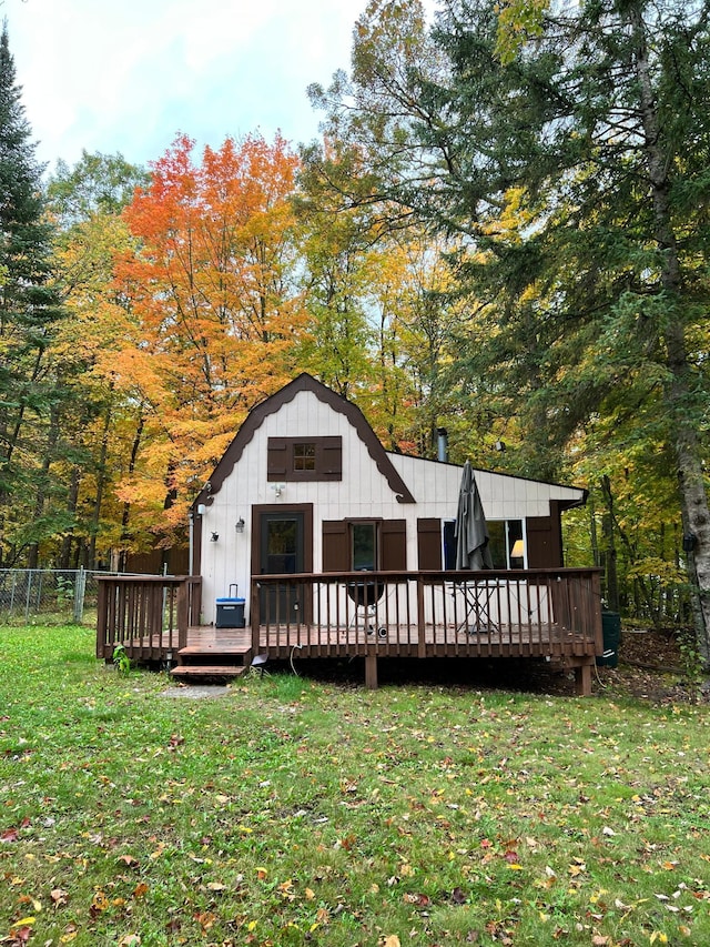 back of property featuring board and batten siding, fence, central AC unit, a deck, and a yard