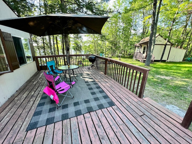 deck with a lawn, an outbuilding, and view of scattered trees
