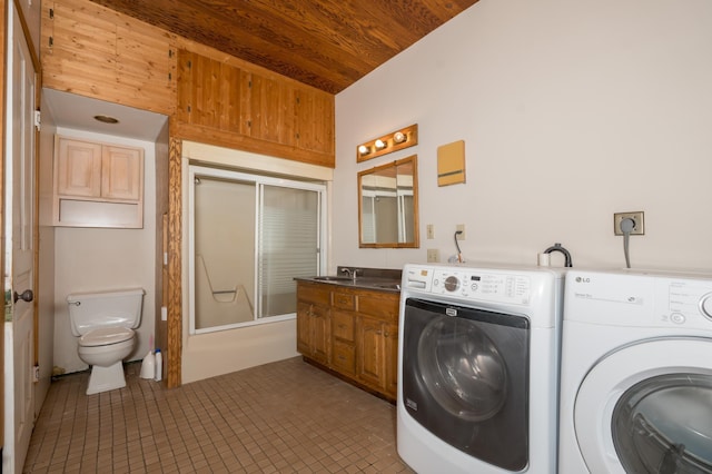 clothes washing area with wooden ceiling, laundry area, tile patterned flooring, and washing machine and clothes dryer