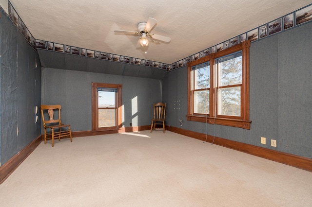 carpeted spare room with ceiling fan, baseboards, and a textured ceiling