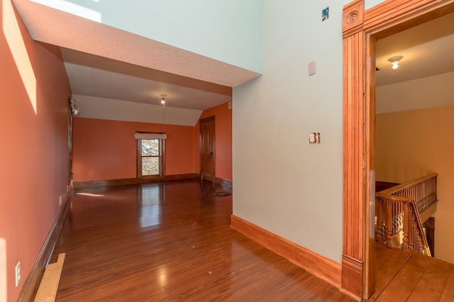 hall with baseboards and wood finished floors