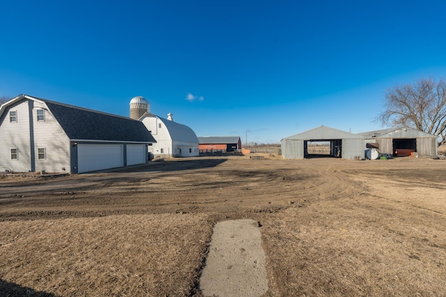 view of yard featuring an outbuilding, a pole building, and a garage