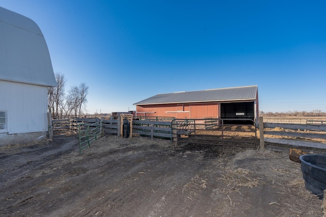 view of outbuilding with a rural view, an exterior structure, and an outbuilding