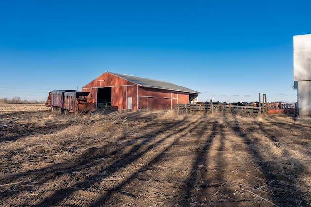 view of outdoor structure with fence and an outbuilding