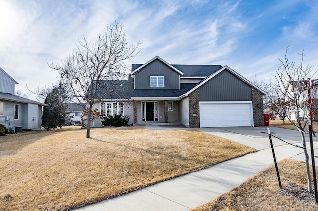 view of front of property with a front yard, brick siding, driveway, and an attached garage