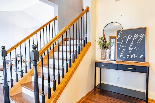 staircase featuring wood finished floors and baseboards