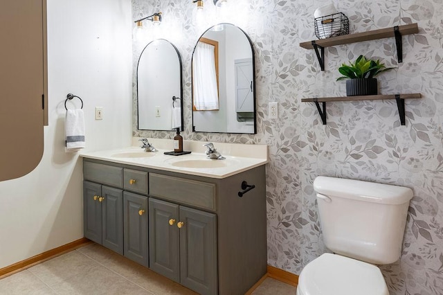 bathroom with tile patterned flooring, a sink, toilet, and wallpapered walls