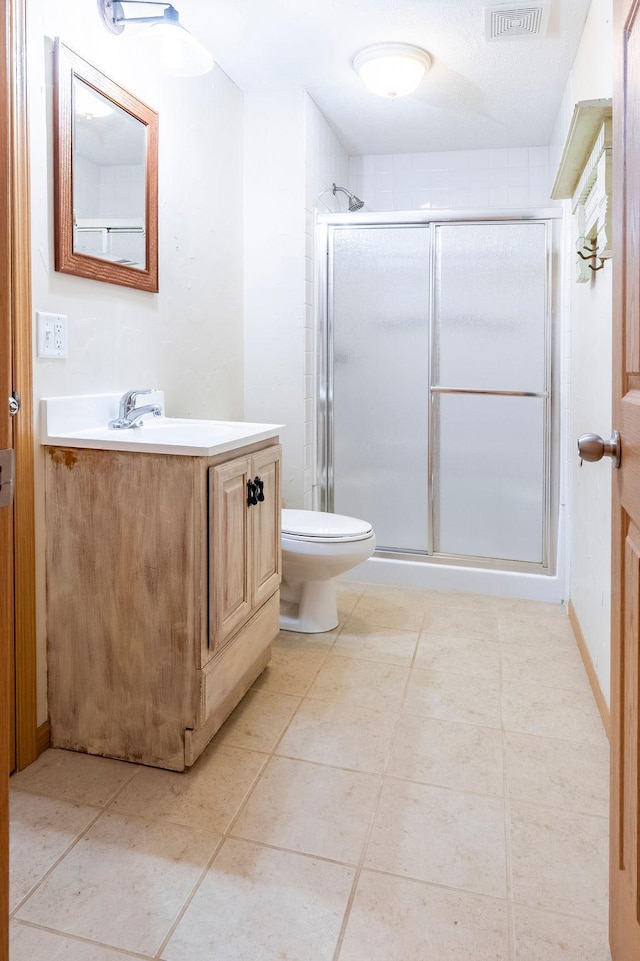 full bath featuring tile patterned flooring, toilet, vanity, visible vents, and a stall shower