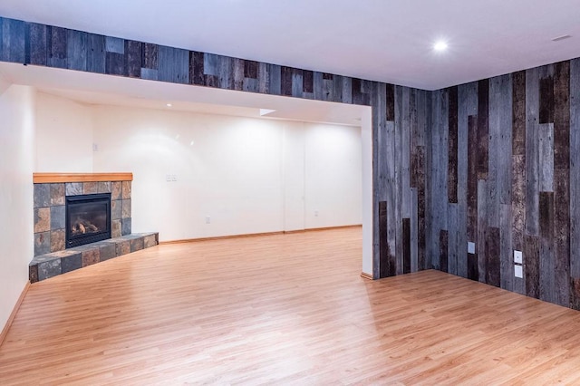 unfurnished living room with recessed lighting, a fireplace, wood finished floors, and baseboards