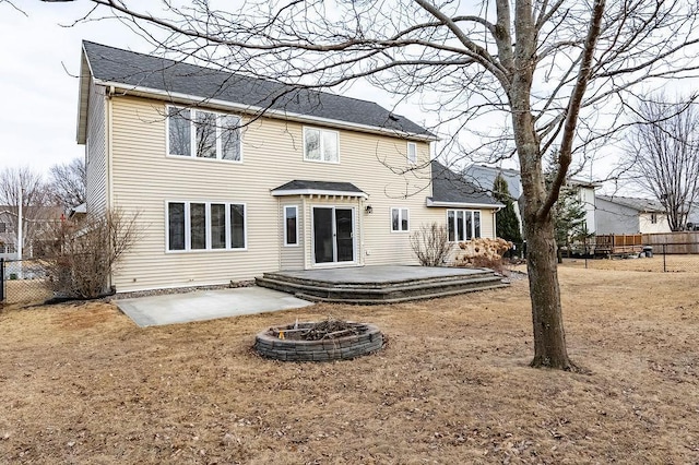 rear view of house with an outdoor fire pit, fence, and a patio