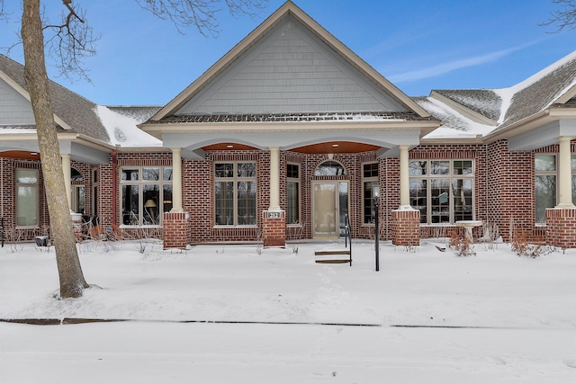 snow covered house with brick siding