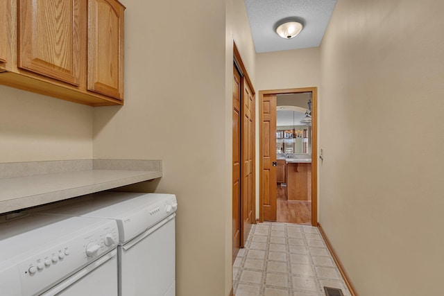 laundry area featuring cabinet space, baseboards, visible vents, washer and dryer, and light floors