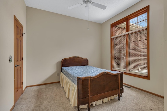 bedroom featuring a ceiling fan, light carpet, and baseboards