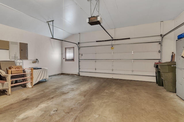 garage with a garage door opener and electric panel