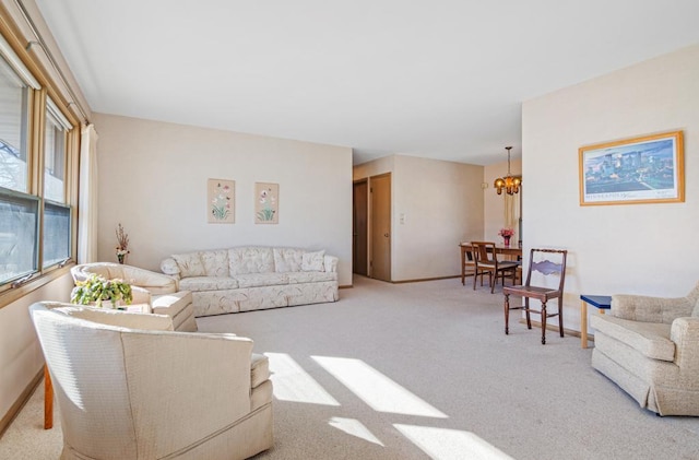 living room featuring a chandelier, carpet flooring, and baseboards