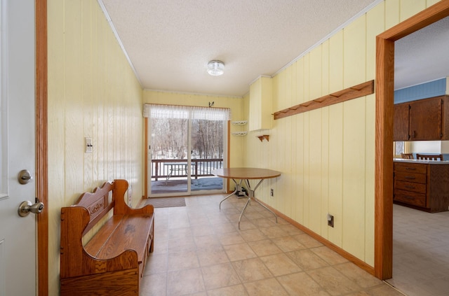 living area with light floors, baseboards, ornamental molding, and a textured ceiling