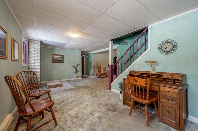 carpeted office space featuring baseboards and a drop ceiling