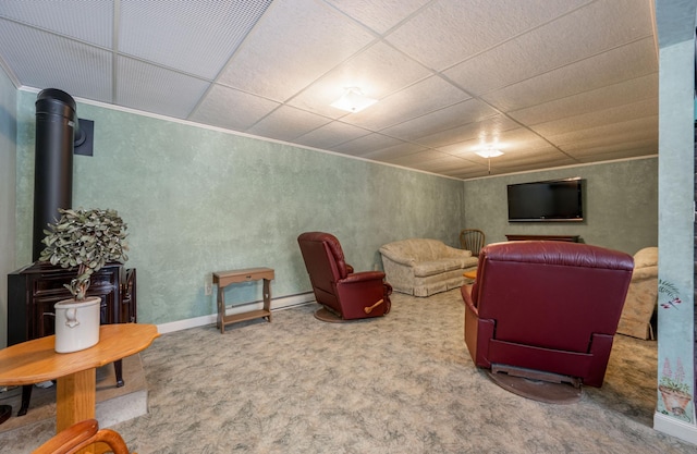 carpeted living area featuring a drop ceiling and baseboards