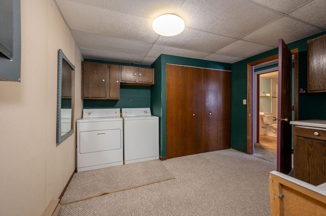 clothes washing area with light carpet, cabinet space, and washer and dryer