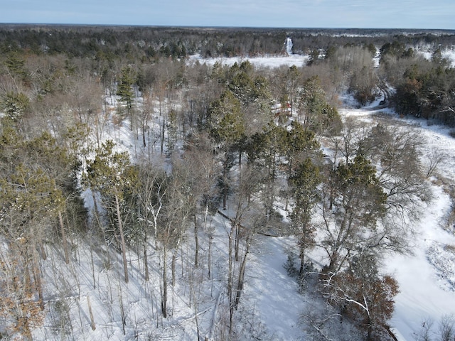 snowy aerial view featuring a forest view