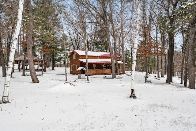 snowy yard with a garage and a gazebo