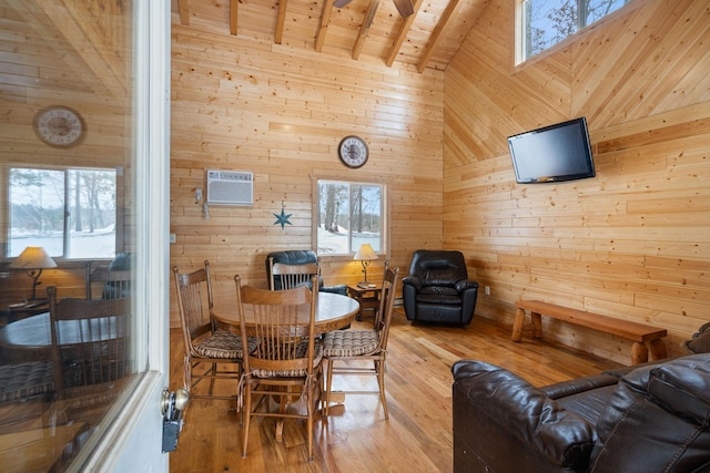 dining room with wood walls, a healthy amount of sunlight, wooden ceiling, and a wall mounted air conditioner