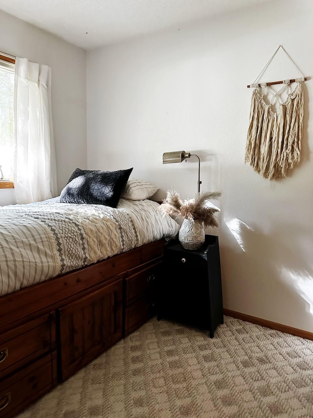 bedroom featuring baseboards and light colored carpet