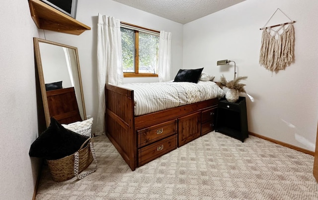 bedroom with a textured ceiling, light carpet, and baseboards