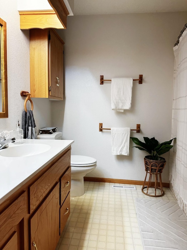 full bath featuring toilet, baseboards, visible vents, and vanity