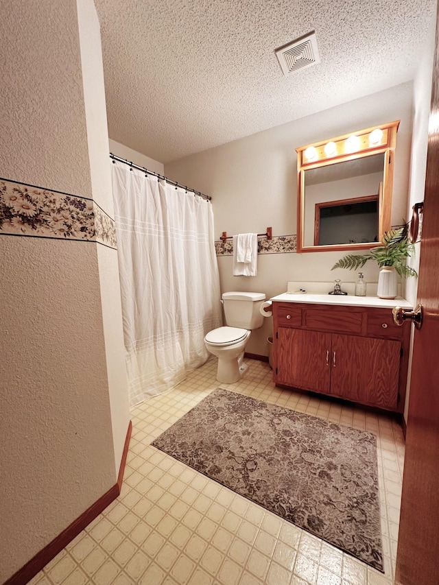 full bath featuring visible vents, vanity, toilet, and a textured ceiling