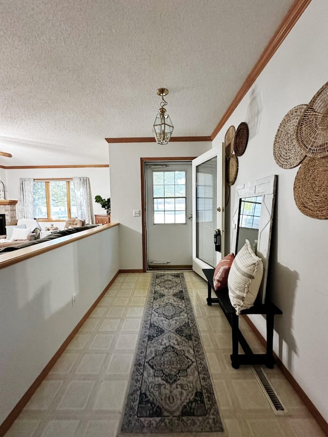 doorway with plenty of natural light, a textured ceiling, and crown molding