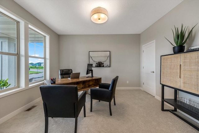 home office featuring baseboards, visible vents, and light colored carpet