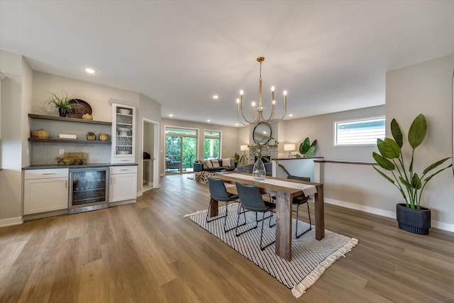 dining area featuring recessed lighting, a chandelier, light wood-type flooring, beverage cooler, and baseboards