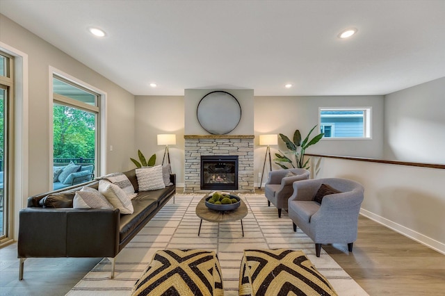 living area with a fireplace, baseboards, wood finished floors, and recessed lighting