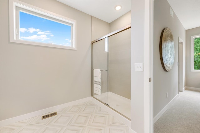 bathroom with visible vents, a shower stall, and baseboards