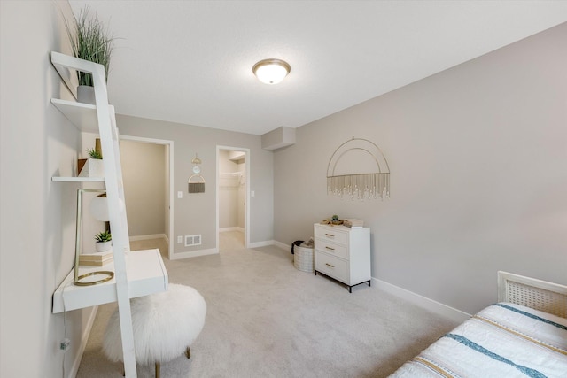 bedroom with baseboards, a spacious closet, visible vents, and carpet flooring