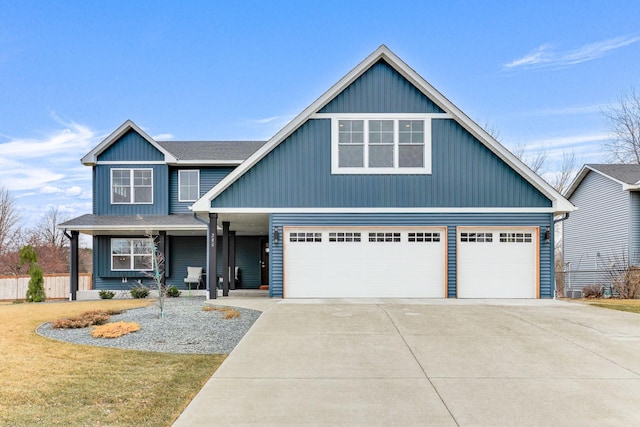 view of front of property with a shingled roof, covered porch, driveway, and a front lawn