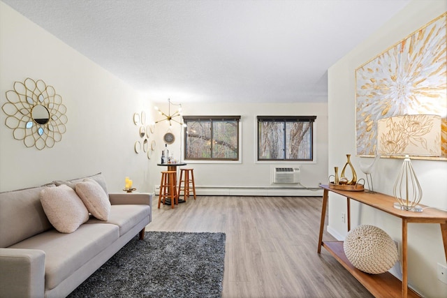 living room featuring an AC wall unit, baseboards, a baseboard heating unit, and wood finished floors