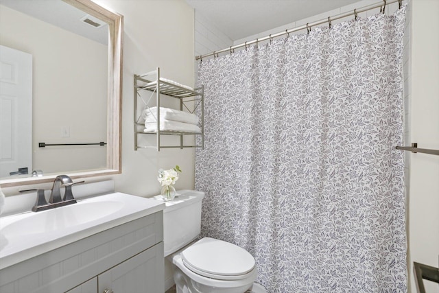 bathroom with vanity, curtained shower, visible vents, and toilet