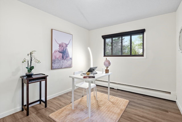 office featuring baseboards, wood finished floors, and baseboard heating