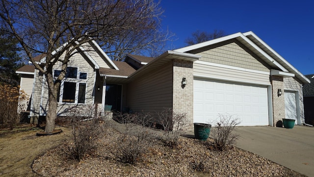 single story home with a garage, concrete driveway, and brick siding