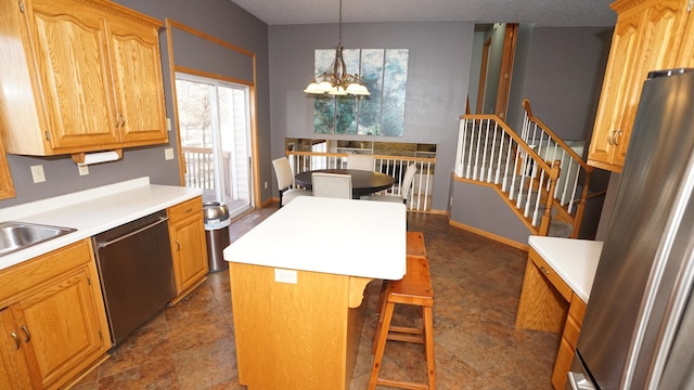 kitchen with a notable chandelier, light countertops, appliances with stainless steel finishes, a center island, and pendant lighting